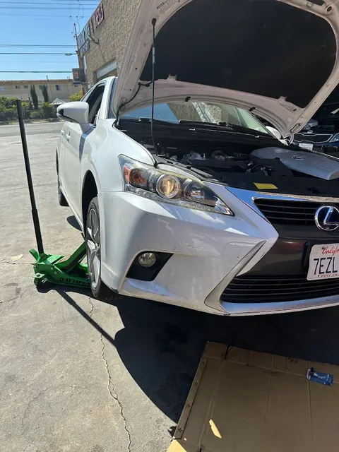 White Lexus hybrid being serviced outside the Hybrid 310 shop